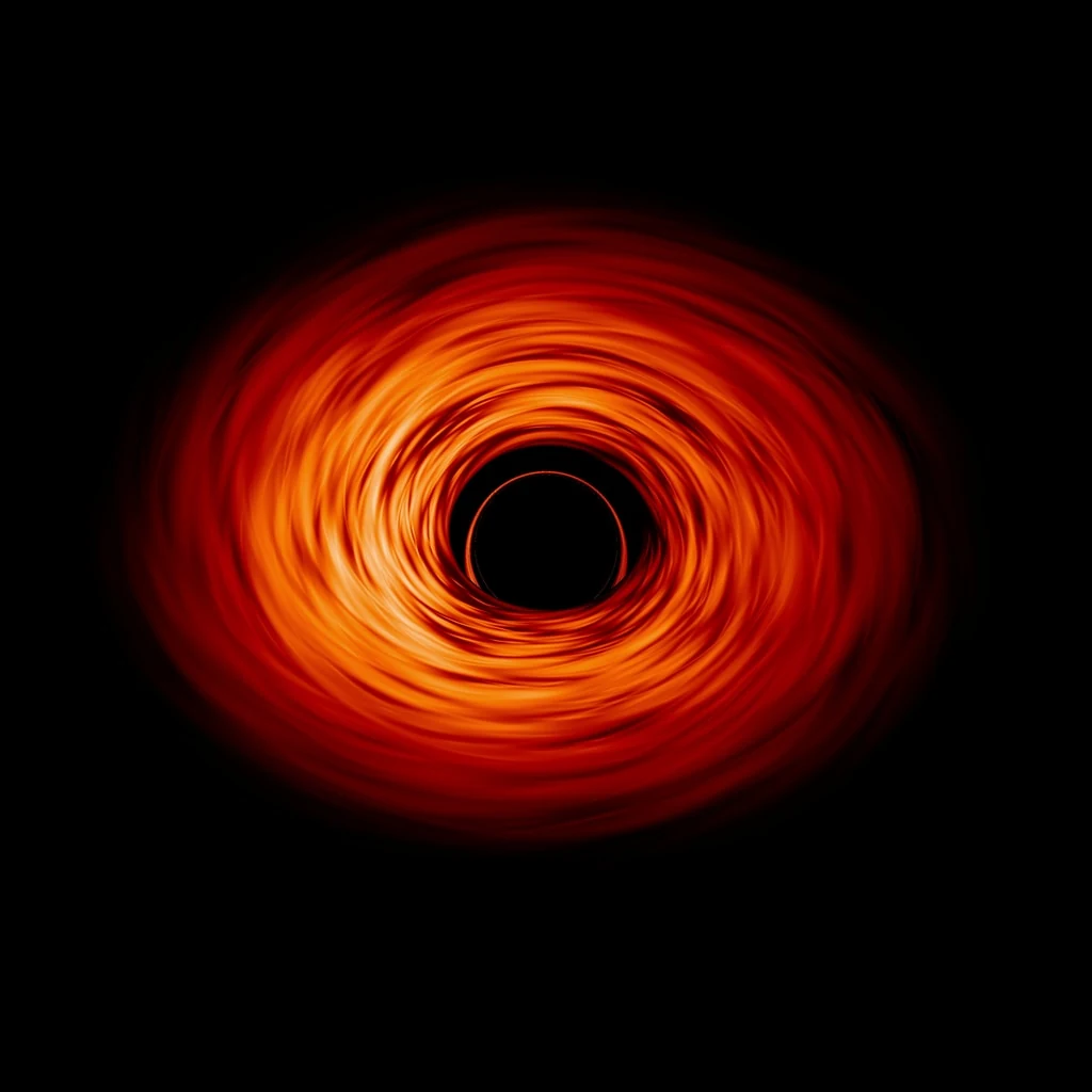 A luminous orange accretion disk curves around the perfectly black shadow of a simulated black hole.